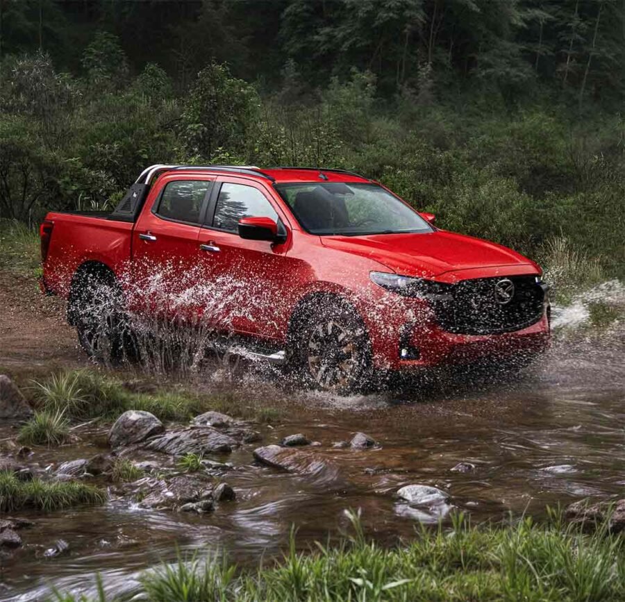 Nueva Mazda BT-50 2025 para México: color rojo en camino difícil, atravesando un río